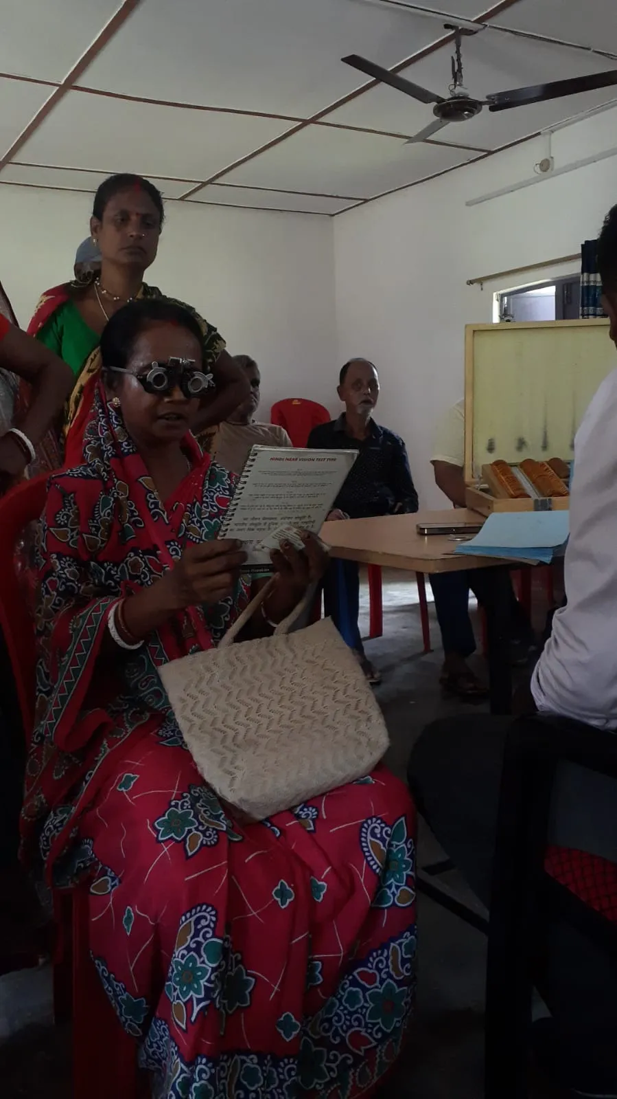 Senior citizen undergoing near vision checkup and refraction test.